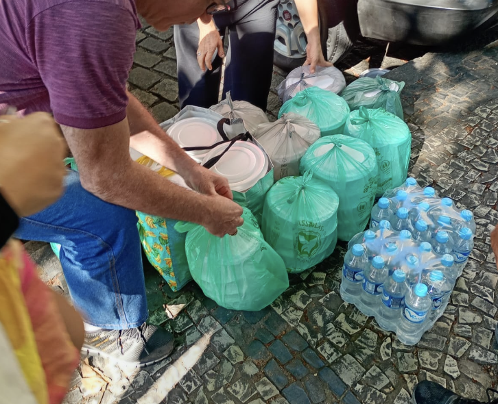 Marmitas e água organizadas para distribuição