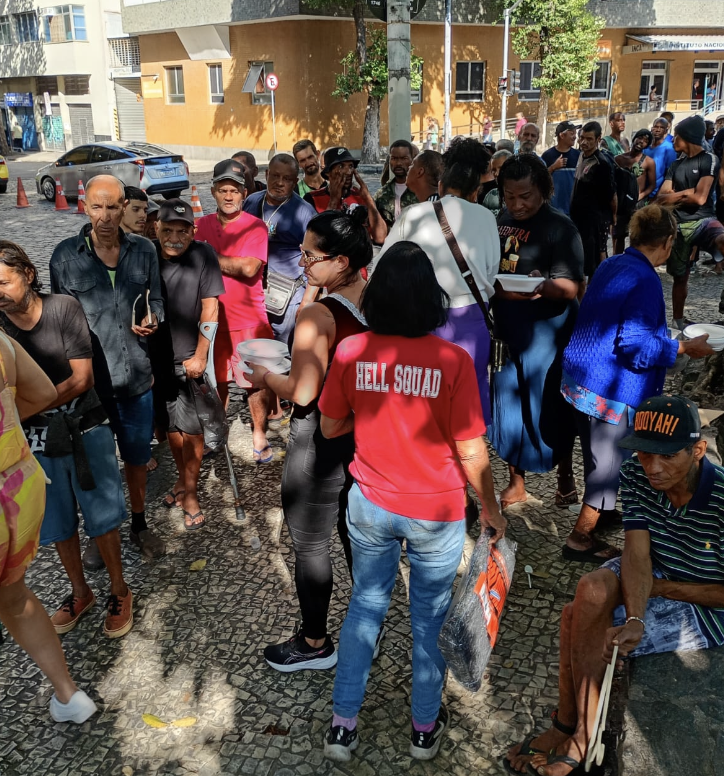 Voluntária entregando marmita durante ação social